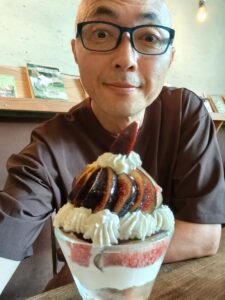 カフェでイチジクのパフェを前に笑顔を見せる筆者